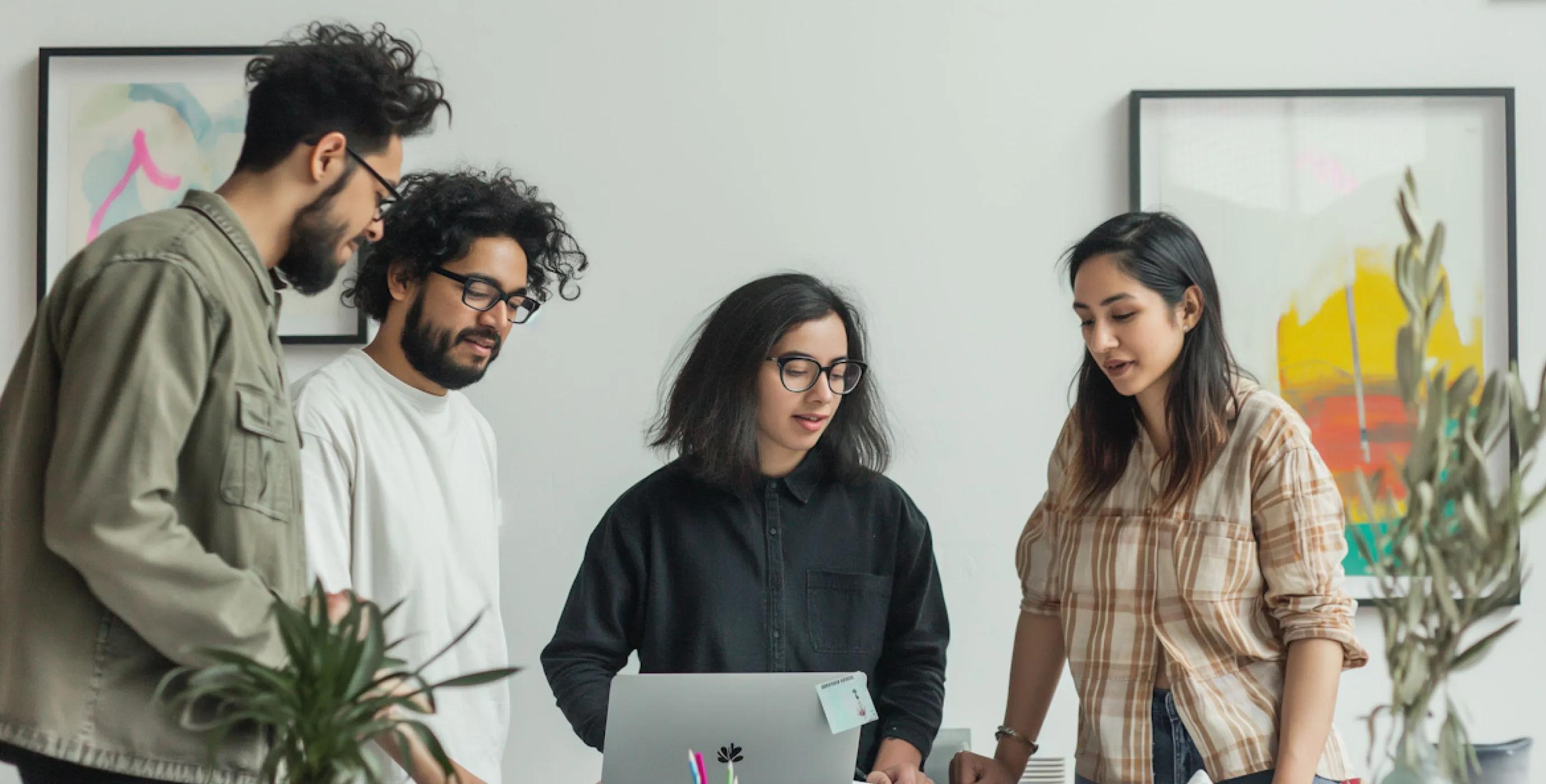 The Slayed team collaborating around a laptop in a modern studio